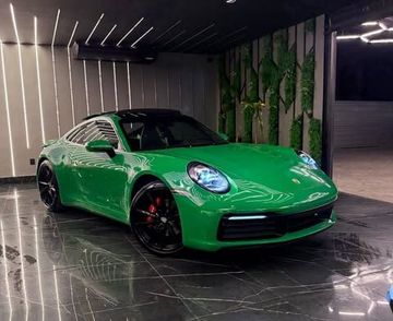Showroom da Empório Motors: faixas de LED na parede, jardim vertical, piso de mármore preto e o Porsche 911 Carrera verde